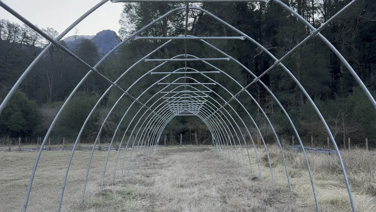 Vista interior de la estructura de arcos del invernadero en Peulla